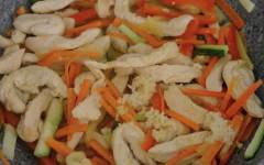 Жаренный рис тяхан с курицей и овощами на сковороде