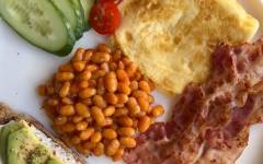 Английский завтрак из яиц, бекона, авокадо, фасоли, помидоров и огурцов