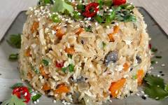 Жареный рис с грибами и яйцом и овощами на сковороде